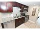 A view of kitchen with granite countertops, stainless steel appliances, and sleek dark cabinetry at 1009 Troon Trce, Winter Springs, FL 32708