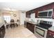 Bright kitchen with granite countertops, stainless steel appliances, and dark wood cabinets, adjacent to cozy dining area at 1009 Troon Trce, Winter Springs, FL 32708