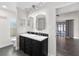 Bathroom featuring double sinks, dark wood cabinets, and modern fixtures with a view to the Primary Bedroom at 1071 Sweet Tree Ct, Apopka, FL 32712
