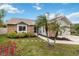 Charming brick home with a well-manicured lawn, landscape and mature palm trees at 1071 Sweet Tree Ct, Apopka, FL 32712