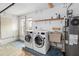 Spacious laundry room featuring a modern washer and dryer, utility sink, and storage shelves at 1071 Sweet Tree Ct, Apopka, FL 32712