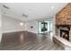 Open living room featuring a brick fireplace, sliding glass doors and wood laminate floors at 1071 Sweet Tree Ct, Apopka, FL 32712