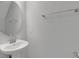 Bright half bathroom featuring a pedestal sink, a round mirror and towel bar at 1117 Pavia Dr, Apopka, FL 32703