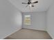 Bright bedroom with neutral carpet, ceiling fan, and large window at 1117 Pavia Dr, Apopka, FL 32703