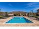 Beautiful community pool featuring crystal clear water, surrounded by brick pavers and lounge seating at 1117 Pavia Dr, Apopka, FL 32703