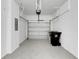 Clean two car garage with gray epoxy floors, bright lighting and white brick walls at 1117 Pavia Dr, Apopka, FL 32703