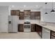 Kitchen area showcases stainless steel appliances, dark wood cabinets, and tile flooring at 1117 Pavia Dr, Apopka, FL 32703