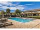 Community pool surrounded by lounge chairs, tables, palm trees, and residential buildings at 1117 Pavia Dr, Apopka, FL 32703