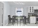 Bright dining area with a window, modern lighting, a four-seater table, and kitchen access at 137 Golfside Cir, Sanford, FL 32773