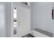 Bright entryway featuring a white front door with sidelight, light gray walls, and a storage bench at 137 Golfside Cir, Sanford, FL 32773