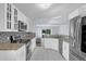 Modern kitchen featuring white cabinets, stainless steel appliances, granite countertops, and tile flooring at 137 Golfside Cir, Sanford, FL 32773