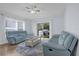 Cozy living room featuring light blue sofas, a decorative rug, and sliding glass doors to the backyard at 137 Golfside Cir, Sanford, FL 32773