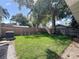 Large, grassy backyard with a tall privacy fence and mature trees, perfect for outdoor activities and relaxation at 16 N Lawsona Blvd, Orlando, FL 32801