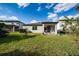 The backyard features green grass, patio with outdoor seating and lush landscaping, perfect for outdoor living at 17216 Goldcrest Loop, Clermont, FL 34714
