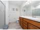 Bright bathroom with double sink vanity, neutral paint, tiled floor and shower with decorative tile accent at 17216 Goldcrest Loop, Clermont, FL 34714