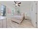 Bright bedroom with ceiling fan, tiled floor, and large windows providing natural light at 17216 Goldcrest Loop, Clermont, FL 34714