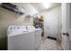 Well-lit laundry room with washer, dryer, wire rack shelving, and access to the exterior at 17216 Goldcrest Loop, Clermont, FL 34714