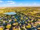 Attractive aerial view features a residential area with mature trees and a tranquil lake in the background at 1865 Sanderling Dr, Clermont, FL 34711