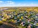 Neighborhood aerial shot shows many houses in the suburbs of a city with lakes and green space nearby at 1865 Sanderling Dr, Clermont, FL 34711