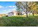Expansive backyard featuring lush green grass and mature trees, perfect for outdoor activities at 1865 Sanderling Dr, Clermont, FL 34711
