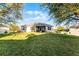 Spacious backyard with lush green lawn and an enclosed patio at 1865 Sanderling Dr, Clermont, FL 34711