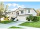 Charming two-story home featuring a well-manicured lawn and a two-car garage at 1865 Sanderling Dr, Clermont, FL 34711