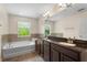 Elegant bathroom features dual sinks, a soaking tub, and a large mirror at 2015 Shalimar Loop, Sanford, FL 32773