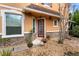 Charming front entrance with stone accents, red front door, and decorative landscaping at 2015 Shalimar Loop, Sanford, FL 32773