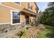 Charming home exterior featuring a red front door, stone accents, and well-maintained landscaping at 2015 Shalimar Loop, Sanford, FL 32773