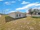 Exterior view of the home's backyard with a simple lawn and privacy fence at 209 Fig Ct, Kissimmee, FL 34759