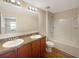 Bathroom featuring a double vanity, full mirror, and a shower-tub combo, designed for convenience and comfort at 209 Fig Ct, Kissimmee, FL 34759