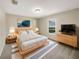Bright bedroom features a wooden bed frame, striped rug, and window with a view at 209 Fig Ct, Kissimmee, FL 34759