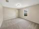 Simple bedroom features neutral carpet, light gray walls and a window offering natural light at 209 Fig Ct, Kissimmee, FL 34759