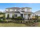 Charming two-story home featuring a manicured lawn, lush landscaping, and inviting front porch seating area at 2141 Weatherly Way, Orlando, FL 32820