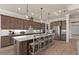Kitchen with a long kitchen island and bar stool seating and modern pendant lighting at 2141 Weatherly Way, Orlando, FL 32820