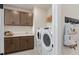 Bright laundry room featuring a front load washer and dryer, cabinets, and a convenient utility sink at 2141 Weatherly Way, Orlando, FL 32820