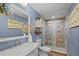 Stylish bathroom with a tiled shower, marble countertop, and blue accent wall with decorative floral accents at 2525 W Ponkan Rd, Apopka, FL 32712