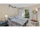 Serene bedroom with a white metal bed, coordinating white dresser, and leafy views out the window at 2525 W Ponkan Rd, Apopka, FL 32712