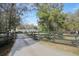 A long paved driveway leads through an ornate black metal gate and fence to a house in the distance at 2525 W Ponkan Rd, Apopka, FL 32712