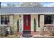 Close-up of the front entrance with a beautiful red door, stone pillars, and manicured greenery at 2525 W Ponkan Rd, Apopka, FL 32712