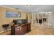 Spacious home office with detailed trim, stylish tile floors, and decorative birch tree accent wall around a fireplace at 2525 W Ponkan Rd, Apopka, FL 32712