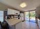 Bright kitchen featuring white cabinets, ample countertop space, and sliding glass doors to the backyard at 3522 Wd Judge Dr, Orlando, FL 32808
