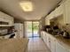 Functional kitchen with white cabinets, ample countertop space, and sliding glass door to backyard at 3522 Wd Judge Dr, Orlando, FL 32808