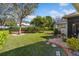 Well-manicured backyard featuring lush green lawn, mature trees, and thoughtful landscaping at 3696 Peacepipe Ct, Clermont, FL 34711