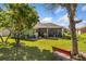 Expansive backyard with lush lawn, mature trees, and a glimpse of the screened-in patio at 3696 Peacepipe Ct, Clermont, FL 34711