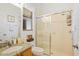 Bathroom featuring granite countertop, tiled shower with glass doors and window with blinds at 3696 Peacepipe Ct, Clermont, FL 34711