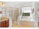 Bright bathroom with soaking tub, glass-enclosed shower, and vanity at 3696 Peacepipe Ct, Clermont, FL 34711