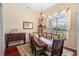 Formal dining room with large window, elegant chandelier, and seating for eight at 3696 Peacepipe Ct, Clermont, FL 34711