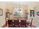 Formal dining room with wood table, chairs, chandelier, and view of front yard at 3696 Peacepipe Ct, Clermont, FL 34711
