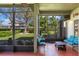 A screened-in lanai offers a serene view of the lush landscaping and backyard at 3696 Peacepipe Ct, Clermont, FL 34711